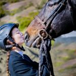 Turnierjacket-Trägerin küsst Pferd