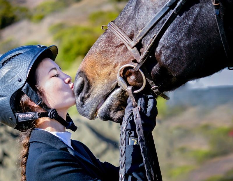 Turnierjacket-Trägerin küsst Pferd